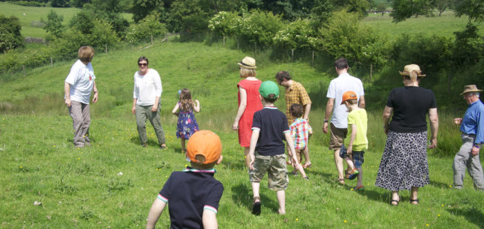 Photo of a group of people, young and old, walking in the countryside.